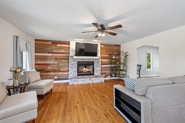 12351 W Warren Dr, Mokena, IL 60448 - living area featuring wood walls, a ceiling fan, arched walkways, a fireplace, and wood finished floors