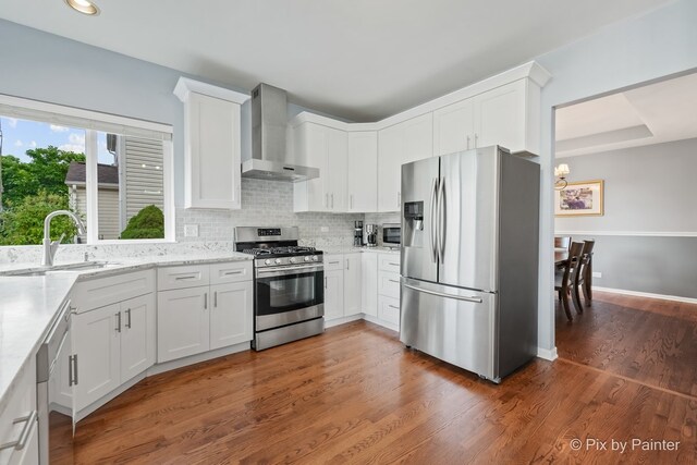 534 Ivory Ln, Bartlett, IL 60103 - kitchen featuring appliances with stainless steel finishes, wall chimney exhaust hood, a chandelier, white cabinetry, and light stone counters