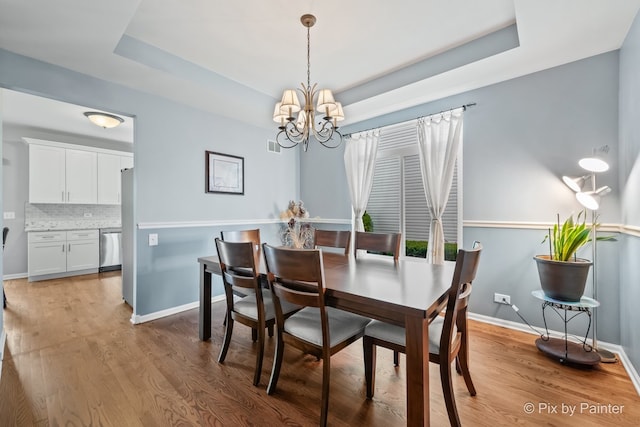 534 Ivory Ln, Bartlett, IL 60103 - dining space with a chandelier, a raised ceiling, and light wood-type flooring