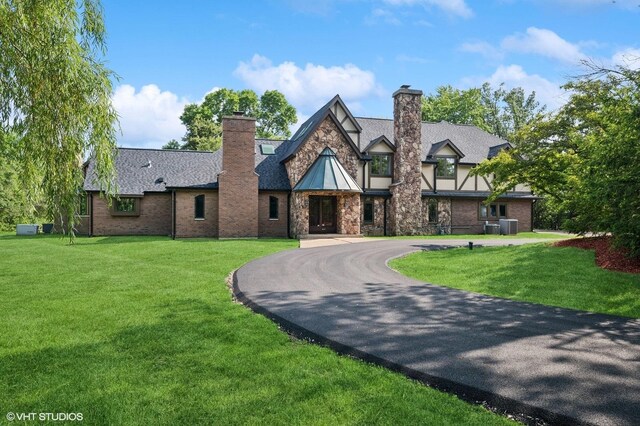 1899 Hilltop Ln, Bannockburn, IL 60015 - tudor house with a chimney, curved driveway, and a front yard