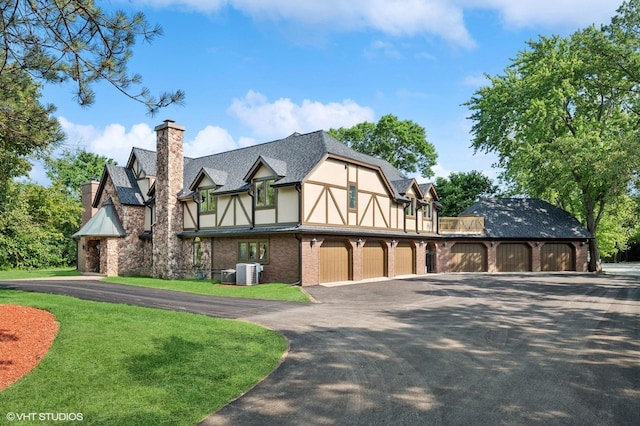 1899 Hilltop Ln, Bannockburn, IL 60015 - english style home featuring a chimney, asphalt driveway, stucco siding, roof with shingles, and brick siding