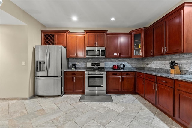 11257 Melrose Ct, Orland Park, IL 60467 - kitchen featuring appliances with stainless steel finishes, decorative backsplash, dark stone countertops, glass insert cabinets, and reddish brown cabinets