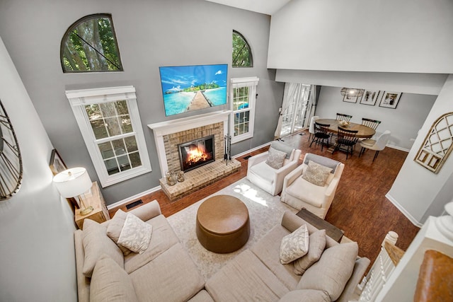 826 N Auburn Woods Dr, Palatine, IL 60067 - living room featuring a towering ceiling, a fireplace, wood finished floors, and plenty of natural light