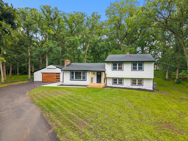 6427 Harlem Rd, Loves Park, IL 61111 - tri-level home with a chimney, a front yard, an outdoor structure, and a garage