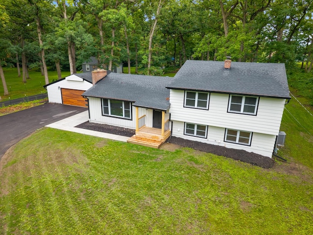 6427 Harlem Rd, Loves Park, IL 61111 - tri-level home featuring a chimney, an outdoor structure, a detached garage, a front yard, and a shingled roof