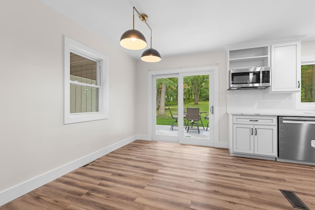 6427 Harlem Rd, Loves Park, IL 61111 - kitchen featuring appliances with stainless steel finishes, plenty of natural light, open shelves, and light wood-type flooring