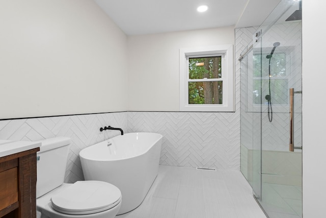 6427 Harlem Rd, Loves Park, IL 61111 - bathroom with a freestanding bath, a stall shower, vanity, wainscoting, and tile walls