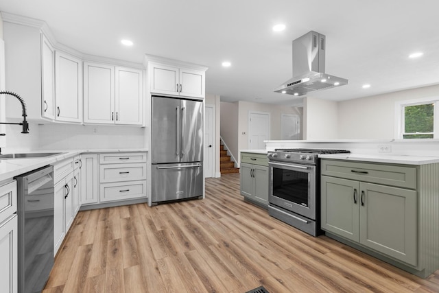 6427 Harlem Rd, Loves Park, IL 61111 - kitchen with premium appliances, island exhaust hood, white cabinetry, light wood-style floors, and green cabinets