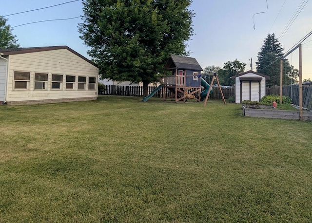 108 Janet Ave, Rochelle, IL 61068 - fenced backyard with a playground, a storage unit, and a vegetable garden