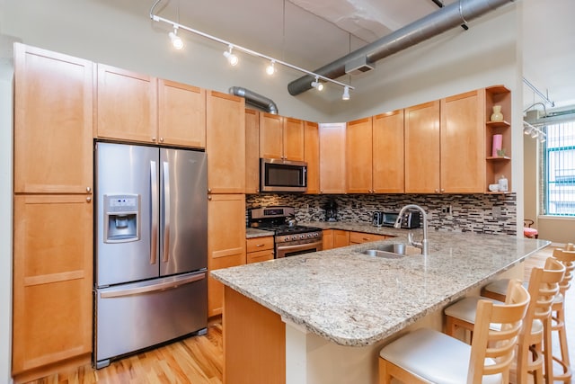 1020 S Wabash Ave Unit 7C, Chicago, IL 60605 - kitchen with appliances with stainless steel finishes, a peninsula, open shelves, light stone countertops, and light wood finished floors