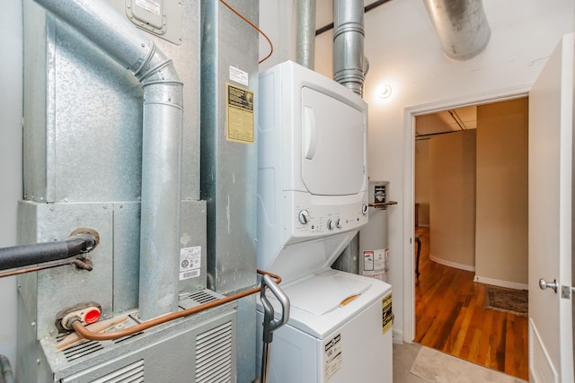 1020 S Wabash Ave Unit 7C, Chicago, IL 60605 - laundry room featuring stacked washer and clothes dryer, heating unit, and wood finished floors