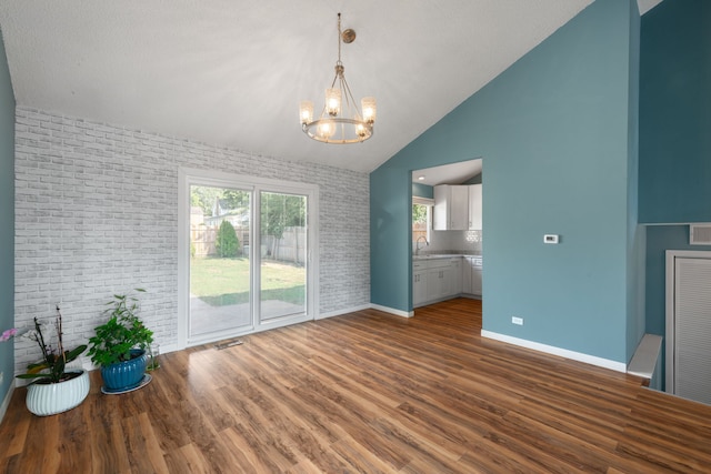 2S464 Cottonwood Ct, Warrenville, IL 60555 - unfurnished dining area with a chandelier, wood finished floors, high vaulted ceiling, and brick wall
