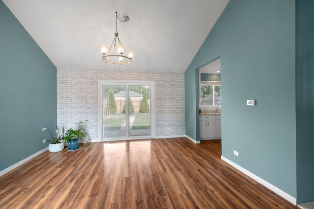 2S464 Cottonwood Ct, Warrenville, IL 60555 - unfurnished dining area with lofted ceiling, a chandelier, healthy amount of natural light, wood finished floors, and brick wall