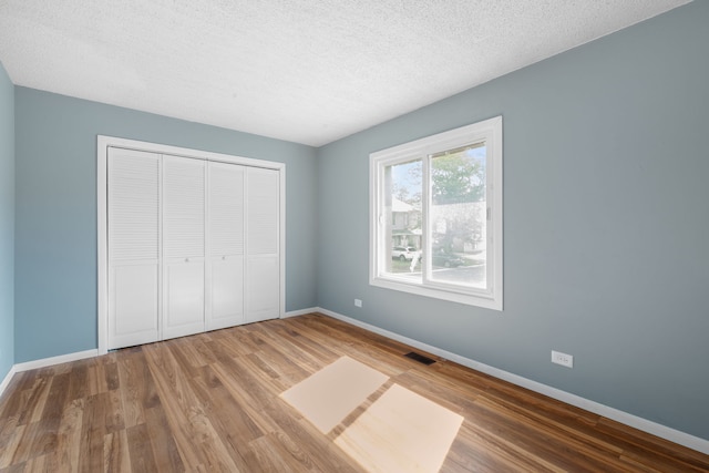 2S464 Cottonwood Ct, Warrenville, IL 60555 - unfurnished bedroom with a closet, wood finished floors, and a textured ceiling