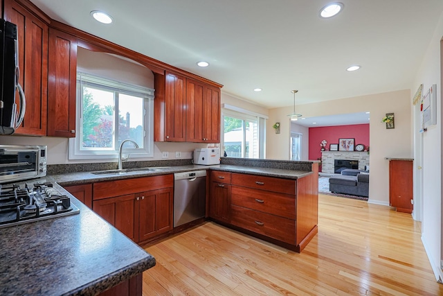 711 W Nichols Rd, Arlington Heights, IL 60004 - kitchen featuring appliances with stainless steel finishes, a peninsula, dark countertops, a stone fireplace, and recessed lighting