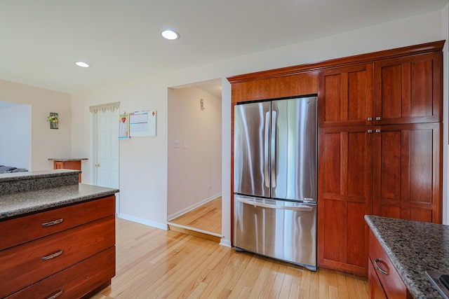 711 W Nichols Rd, Arlington Heights, IL 60004 - kitchen featuring freestanding refrigerator, light wood-style floors, recessed lighting, brown cabinets, and dark stone counters