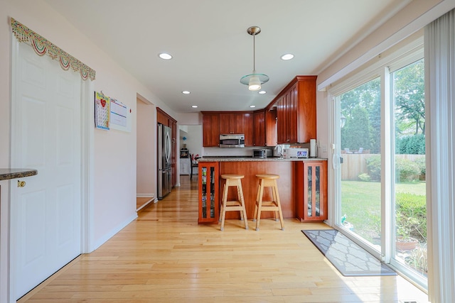 711 W Nichols Rd, Arlington Heights, IL 60004 - kitchen with appliances with stainless steel finishes, a peninsula, recessed lighting, light wood-type flooring, and hanging light fixtures