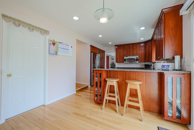 711 W Nichols Rd, Arlington Heights, IL 60004 - kitchen featuring appliances with stainless steel finishes, a peninsula, recessed lighting, light wood finished floors, and light stone countertops