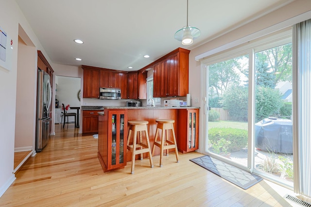 711 W Nichols Rd, Arlington Heights, IL 60004 - kitchen with stainless steel appliances, light wood-style flooring, a peninsula, hanging light fixtures, and recessed lighting