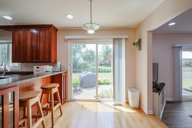 711 W Nichols Rd, Arlington Heights, IL 60004 - kitchen featuring light wood-style flooring, pendant lighting, recessed lighting, a breakfast bar area, and stone counters