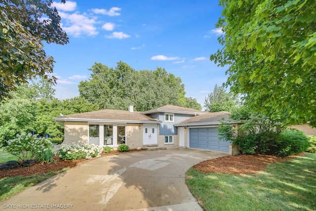 353 Eagle Ln, Bloomingdale, IL 60108 - tri-level home featuring driveway, an attached garage, brick siding, and a chimney