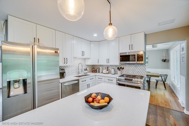 353 Eagle Ln, Bloomingdale, IL 60108 - kitchen with appliances with stainless steel finishes, light countertops, wood finished floors, white cabinets, and tasteful backsplash