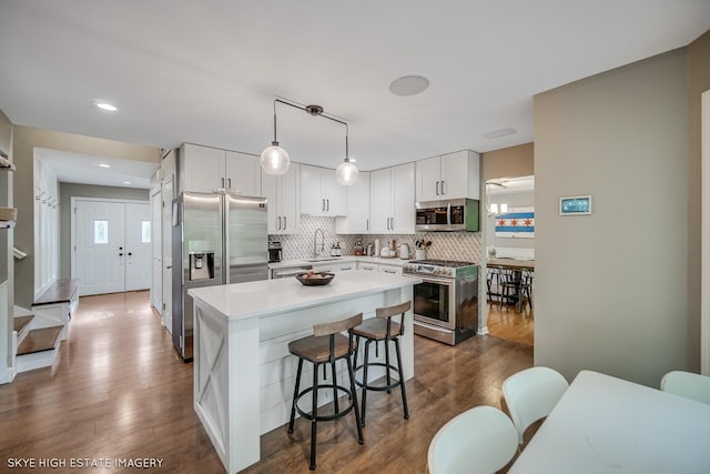353 Eagle Ln, Bloomingdale, IL 60108 - kitchen with appliances with stainless steel finishes, a breakfast bar, decorative backsplash, white cabinets, and light countertops