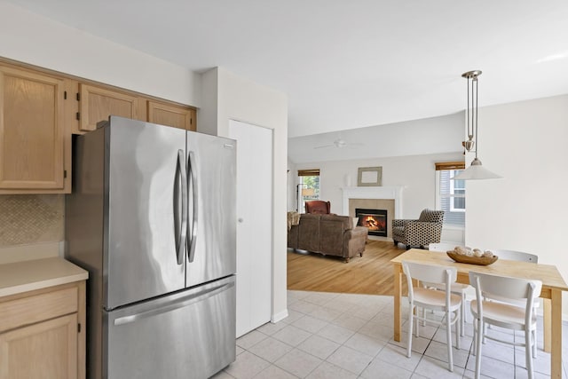 1439 Blue Heron Dr, Crystal Lake, IL 60014 - kitchen with freestanding refrigerator, a ceiling fan, a lit fireplace, light tile patterned flooring, and pendant lighting