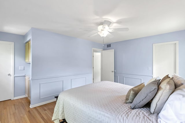 1439 Blue Heron Dr, Crystal Lake, IL 60014 - bedroom featuring light wood-style floors, a decorative wall, wainscoting, and ceiling fan