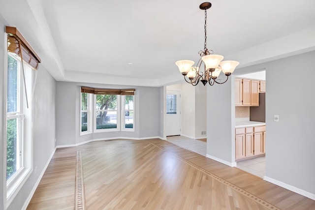 1439 Blue Heron Dr, Crystal Lake, IL 60014 - unfurnished room with plenty of natural light, a chandelier, and light wood-type flooring