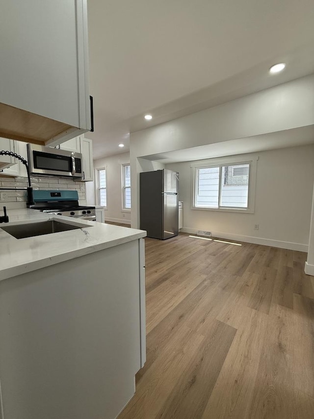 11804 S State St, Chicago, IL 60628 - kitchen with stainless steel appliances, light wood-style flooring, recessed lighting, white cabinetry, and backsplash