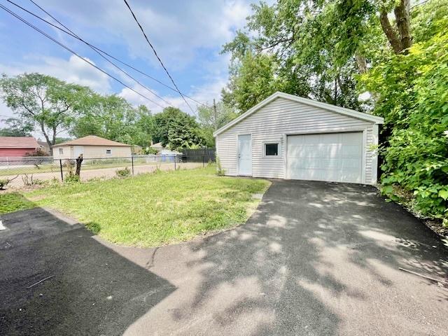 132 W 126th Pl, Chicago, IL 60628 - view of yard featuring a garage, an outdoor structure, and asphalt driveway