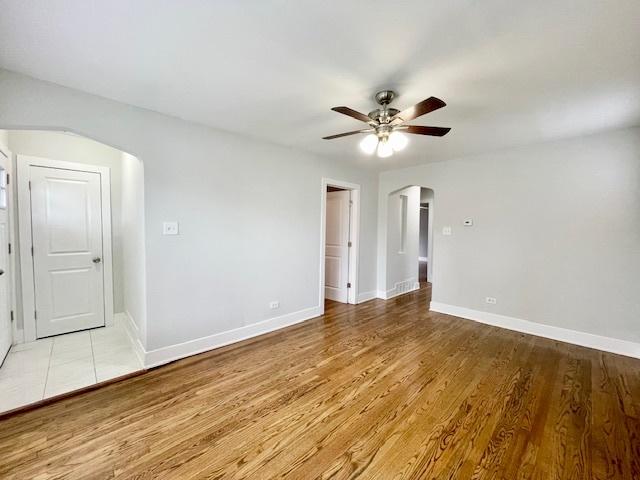 132 W 126th Pl, Chicago, IL 60628 - unfurnished room featuring arched walkways, a ceiling fan, and light wood-type flooring