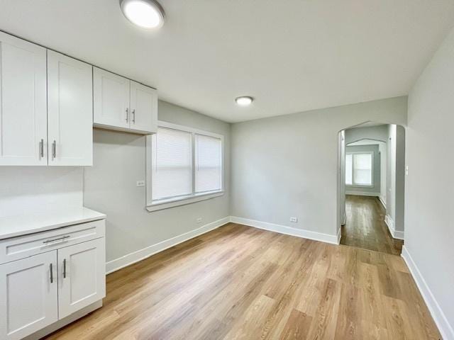 132 W 126th Pl, Chicago, IL 60628 - unfurnished dining area featuring arched walkways and light wood-style floors