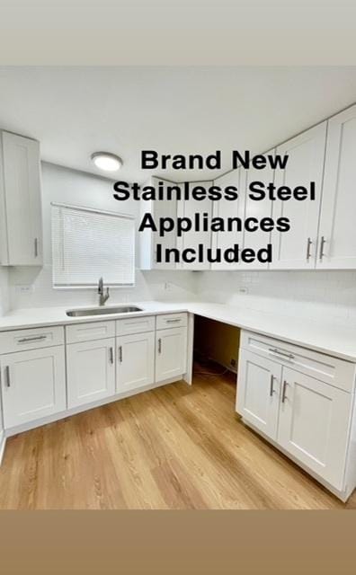 132 W 126th Pl, Chicago, IL 60628 - kitchen featuring white cabinetry, light wood-style floors, and light countertops