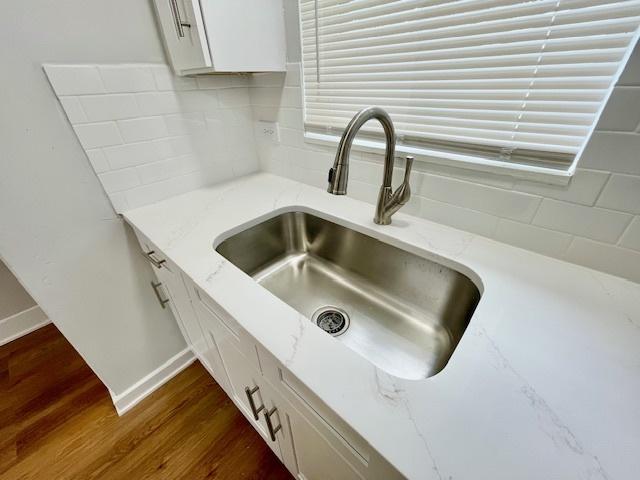 132 W 126th Pl, Chicago, IL 60628 - kitchen view of white cabinets, dark wood-type flooring, backsplash, and light stone counters