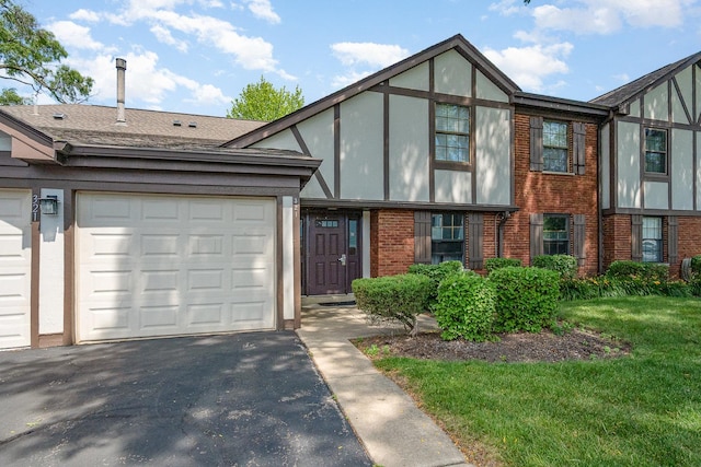 321 Woodbury Ct Unit D2, Schaumburg, IL 60193 - view of front facade with brick siding, driveway, a garage, and a front yard