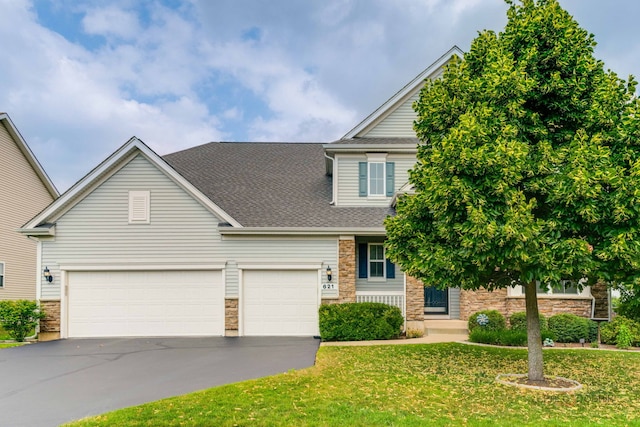621 Blazing Star Dr, Lake Villa, IL 60046 - view of front of house with a front lawn, driveway, stone siding, and roof with shingles