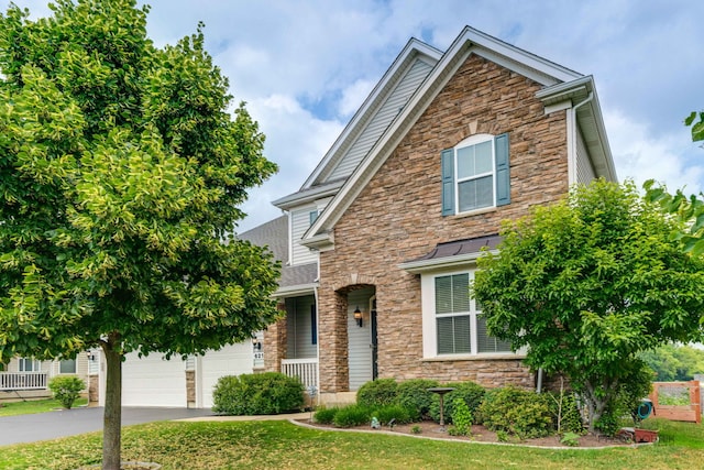 621 Blazing Star Dr, Lake Villa, IL 60046 - traditional-style house featuring stone siding, asphalt driveway, and a front lawn