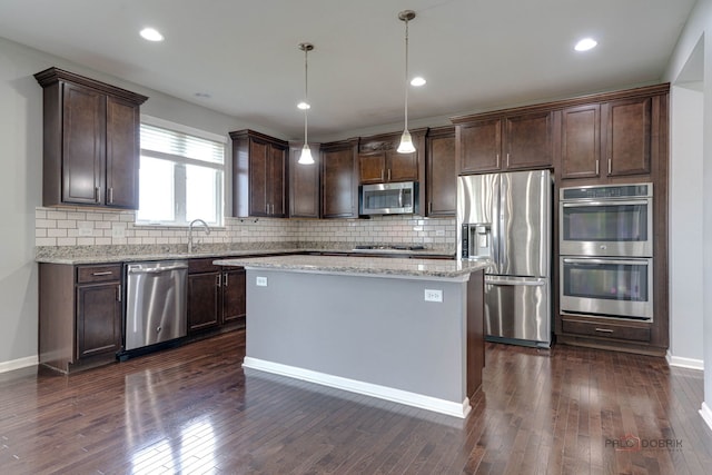 621 Blazing Star Dr, Lake Villa, IL 60046 - kitchen with stainless steel appliances, dark brown cabinetry, decorative backsplash, light stone countertops, and recessed lighting