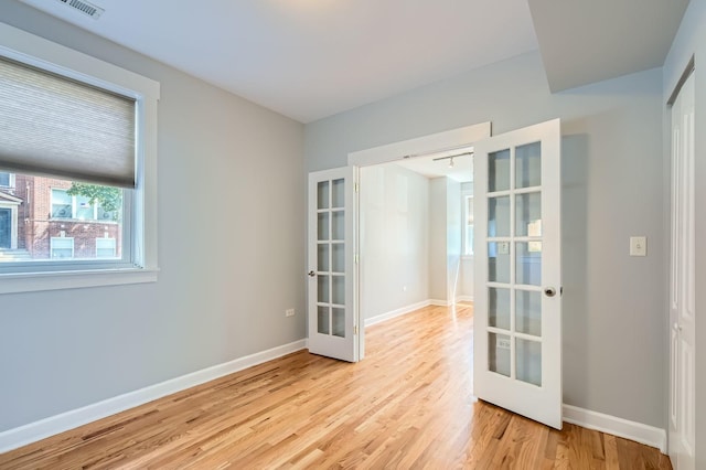 4056 N Albany Ave Unit G, Chicago, IL 60618 - empty room with french doors and light wood-style flooring