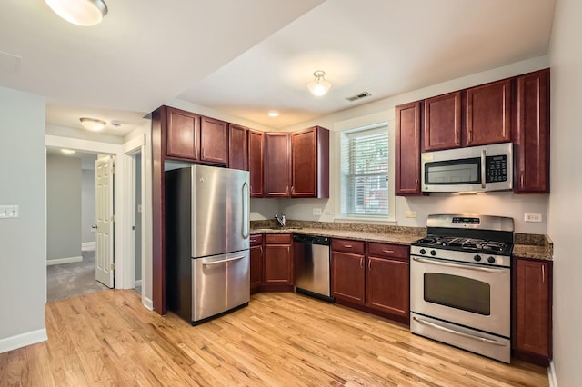 4056 N Albany Ave Unit G, Chicago, IL 60618 - kitchen featuring appliances with stainless steel finishes, light wood-style flooring, and dark stone counters