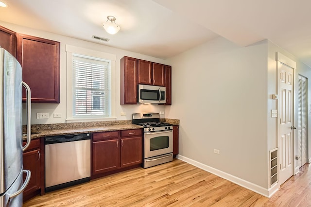 4056 N Albany Ave Unit G, Chicago, IL 60618 - kitchen with appliances with stainless steel finishes, light wood-type flooring, and dark stone countertops