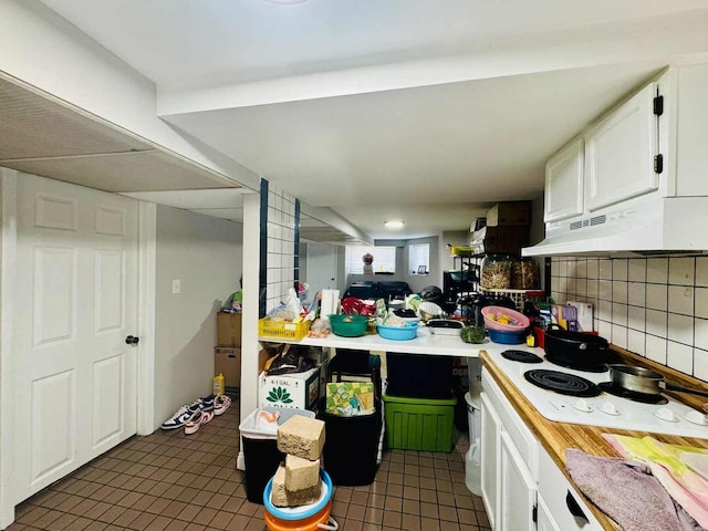5221 W Montrose Ave, Chicago, IL 60641 - kitchen featuring under cabinet range hood, white cabinetry, light countertops, and tile patterned floors