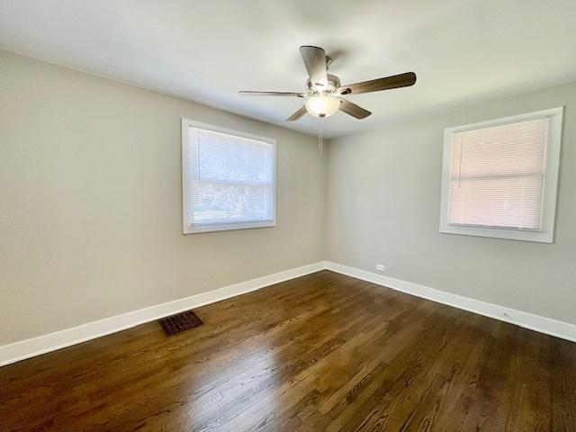 10049 S Calhoun Ave, Chicago, IL 60617 - empty room with ceiling fan and dark wood-type flooring