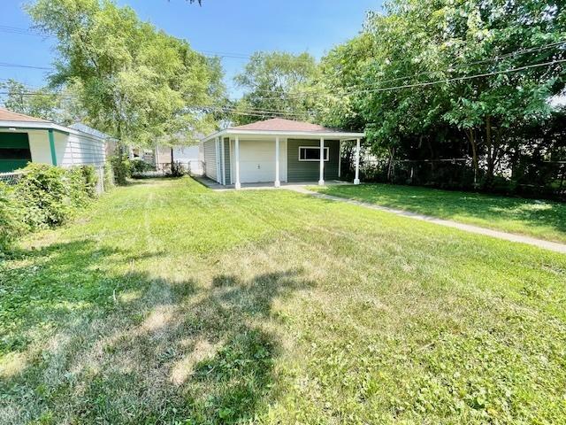 10049 S Calhoun Ave, Chicago, IL 60617 - view of green lawn featuring a garage