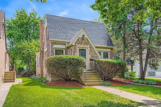 4017 Park Ave, Brookfield, IL 60513 - tudor-style house with brick siding, a front lawn, and a chimney