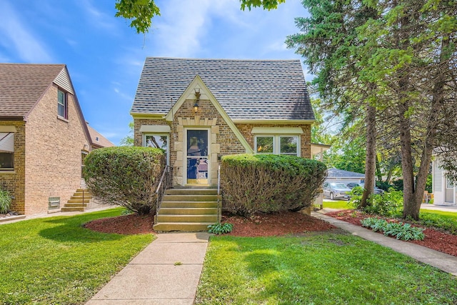 4017 Park Ave, Brookfield, IL 60513 - tudor-style house featuring brick siding, a front lawn, and roof with shingles