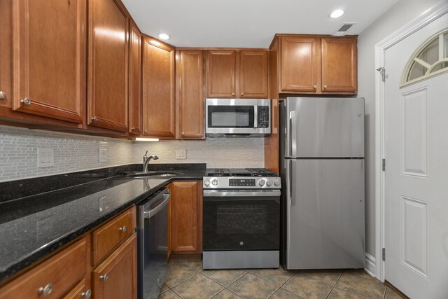 5656 N Kimball Ave Unit Gs, Chicago, IL 60659 - kitchen with appliances with stainless steel finishes, decorative backsplash, dark tile patterned floors, brown cabinetry, and recessed lighting