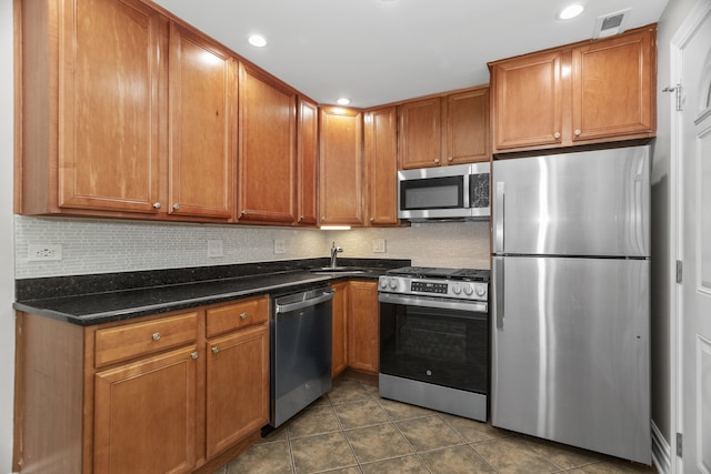 5656 N Kimball Ave Unit Gs, Chicago, IL 60659 - kitchen featuring stainless steel appliances, dark tile patterned flooring, brown cabinets, decorative backsplash, and recessed lighting